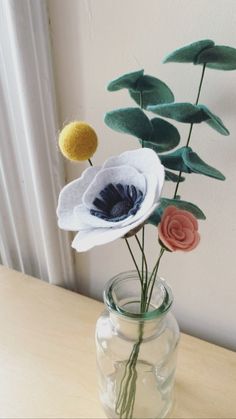 three flowers in a vase on a table