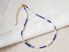 This blue beaded necklace is a lovely necklace with blue and white beads and pearls. In this gold-plated necklace, I have paired blue, white, gold and striped seed beads with genuine white and blue freshwater pearls. The beading wire I use is flexible high-quality stainless steel, composed of multiple twisted tiny wires that are nylon coated to protect the beads. The length of the necklace is 15 inches (38 cm), with a 2,5 inches (6 cm) extension chain - so you can adjust the length of your necklace between 15 inches and 17.5 inches (38 - 44,5 cm). If you would like to have the necklace shorter or longer, just send me a message - I'm happy to personalize this necklace for you. See my whole jewelry collection: https://www.etsy.com/shop/Tazelry ♥ Jewelry care ♥ It's important to keep your jew Blue Dainty Beaded Choker Necklace, Dainty Blue Beaded Choker Necklace, Blue Pearl Necklace With Tiny Beads As Gift, Blue Pearl Necklace With Tiny Beads For Gift, Blue Pearl Necklace With Spacer Beads For Gift, Nautical Necklace, Beads Choker, Colorful Necklace, Sweet Necklace