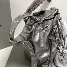 Balenciaga 's popular "Le Cagole" series is a modern interpretation of its "City" handbags - reshaped into a bucket bag design to inject a new soul into it. The large size adds two round top handles, combining classic and Modern trends are perfectly integrated. On the basis of retaining the original DNA of the motorcycle bag's flat rivets, delicate buckles and tassel zippers, it adds adjustable woven shoulder straps and a cute and playful heart-shaped mirror, which perfectly softens the neutral temperament of the original version. .
Original burst sheepskin imported from Italy (explosion fine lines can be seen)
Large Size: 30*23*17cm Designer Bucket Satchel With Handles, High-end Bucket Satchel, Chic Bucket Bag With Silver-tone Hardware And Double Handle, Chic Bucket Bag With Silver-tone Hardware For Shopping, Chic Shopping Bucket Bag With Silver-tone Hardware, Chic Silver Leather Bucket Bag, Designer Crossbody Bucket Bag For Shopping, Chic Silver Bucket Bag With Silver-tone Hardware, Designer Bucket Satchel For Evening