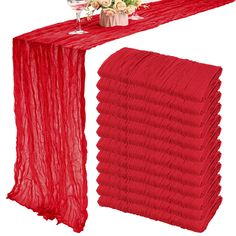 a red table runner with wine glasses and flowers on it