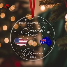 a christmas ornament hanging from a tree with lights in the background and an american flag on it