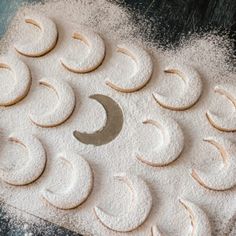 several moon and crescent shaped cookies on a table with powdered sugar in the middle