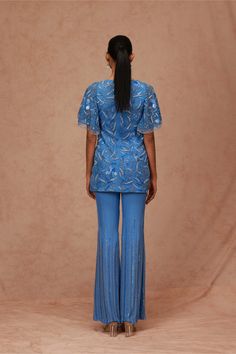 Editor's Note Featuring A Tulle Base Tunic With Flared Sleeves, Embroidered With Floral Sequin Motifs And Is Well Paired With A Chiffon Flared Pants With Linear Beading. Color: Blue Fabric: Tulle, Chiffon Component: Tunic And Pant Care: Dry Clean Only About the Designer Shriya Som is engaged in the design, manufacture, and distribution of luxury pret, occasion wear, and bespoke garments specializing in evening wear. The brand is defined to have an understated aesthetic that epitomizes a graceful Tunic With Pants, Blouse Yoke, Embroidery Beaded, Sequin Tunic, Chiffon Tunic, Pattern Embroidery, Flared Pants, Fabric Silk, Blue Silk