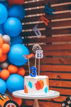 a birthday cake with colorful decorations and balloons