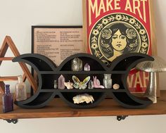 a shelf with various items on it and a poster in the background that says make art