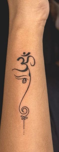 a woman's wrist tattoo with an omen symbol on her left side arm