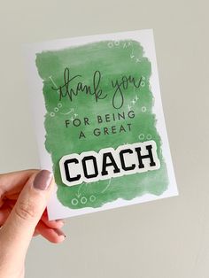 a hand holding up a card that says thank you for being a great coach