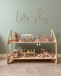 a wooden shelf with toys on it and the words let's play above it