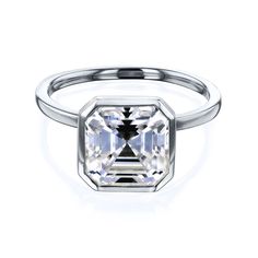 an emerald cut diamond ring on a white background