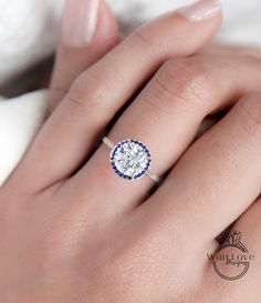 a woman's hand with a blue and white diamond ring