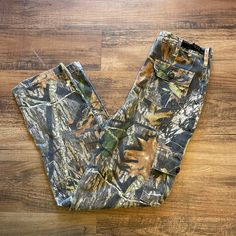 a pair of camouflage pants sitting on top of a wooden floor