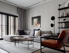 a living room filled with lots of furniture next to a window covered in shades of gray