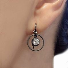 These bezel set earrings look industrial, modern and vintage all at once. Details: handmade ear wires in 18k palladium white gold spring wire and matte-finished in black rhodium polished inner bezel, matte outer bezel, and dangling circle to accentuate the diamond in blackened 18k palladium white gold diamonds in two sizes, GH SI2 quality, and color other diamond sizes between .10 ct. to 1.0 ct. or in blue sapphire or ruby earrings shown are .50 total carat weight size made in New York Dimension Bezel Set Earrings, Earrings Circle, Ruby Earrings, Black Rhodium, Diamond Sizes, Modern Jewelry, White Gold Diamonds, Ear Wires, Blue Sapphire