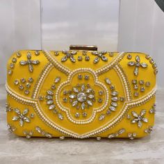 Introducing our designer Handmade clutches. With detailed intricate work, these purses are perfect for a daily wear as well as party wear. Comes with a detachable chain, you can easily switch from a hand purse to a crossbody. Spacious enough to fit daily essential needs as well as all kind of Phones. This gorgeous clutch in yellow with stone work is such an elegant piece. ALL SALES ARE FINAL. KINDLY MESSAGE ME FOR ANY INQUIRIES. Designer Pouch Box Bag For Party, Designer Rectangular Pouch For Evening, Designer Party Pouch Box Bag, Formal Festive Pouch, Chic Yellow Clutch As A Gift, Chic Yellow Clutch For Gift, Chic Yellow Clutch As Gift, Chic Yellow Clutch For Formal Occasions, Embellished Evening Clutch For Festivals