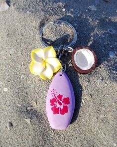 Hawaiian style summer fashion. Surfboard shaped keychain or beach bag charm, adorned with two yellow and white plumeria flower charms and a half coconut. The surfboard is made from lavender colored clay and decorated with a dark pink hibiscus. Perfect gift for surf and beach lovers of all ages. APPROXIMATE MEASUREMENTS: Total length: 8 cm (around 3,15" inches) Surf: 3 x 1.8 x 0.8 cm (1,18" x 0,71" x0,31" inches) Flower: 2 x 2 x 1 cm (0,79" x 0,79" x 0,39" inches) Coconut: 1.5 x 1.5 x 0.7 cm (0,5 Hibiscus Flower Keychain, Clay Summer Ideas, Coconut Girl Accessories, Coconut Girl Wishlist, Summer Things To Buy, Summer Clay Ideas, Surf Boards Aesthetic, Surf Keychain, Hibiscus Keychain