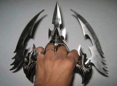 a hand holding several knives in it's claws