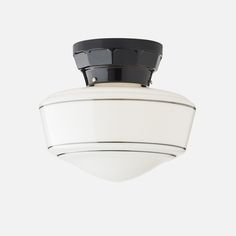 an overhead view of a white ceiling fixture with black trim and a round light fixture