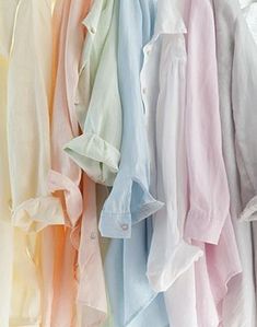 many different colored shirts hanging on a rack