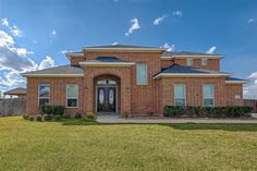 a brick house with green grass in front