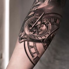 a man's arm with a clock tattoo on it