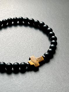 - Sleek and modern mens cross beaded bracelet with black onyx and tiger eye cross bead. This bracelet can be dressed up or dressed down for everyday wear. Other coordinating pieces and boys sizes in shop. Beaded on high quality stretch cord and secured. - 14mm tiger cross bead    6mm matte black onyx beads    hematite spacer beads - Each purchase is sent in a velvet drawstring jewelry bag, making the perfect gift for husband, boyfriend gift, bracelet for dad, someone special or just for yourself Prayer Bead Bracelet, Godfather Gifts, Christian Bracelets, Gift Bracelet, Mens Crosses, Bracelet Men, Onyx Bracelet, Mens Beaded Bracelets, Christian Jewelry