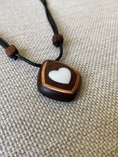 Size: 3.5 x 3 cm Immerse yourself in a world of romance with our elegant mahogany heart pendant with mother-of-pearl inlays. Every detail of this unique decoration embodies warmth and tenderness, creating a unique atmosphere. Our artisans carefully craft the pendant by hand, using only the finest materials. Mahogany adds natural warmth and sophistication, reproducing its unique patterns and textures. Mother-of-pearl inserts give the product a magical shine and a gentle glow that attracts attenti Handmade Mahogany Jewelry Gift, Mahogany Handmade Jewelry For Gift, Handmade Mahogany Jewelry For Gift, Brown Square Pendant Jewelry For Gift, Unique Mahogany Jewelry For Gift, Handmade Mahogany Necklace For Gift, Brown Heart Shaped Jewelry With Heart Beads, Mother Of Pearl Heart Pendant Jewelry Gift, Brown Heart-shaped Spiritual Jewelry