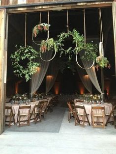 an open barn door with tables and chairs set up for a wedding reception in front of it