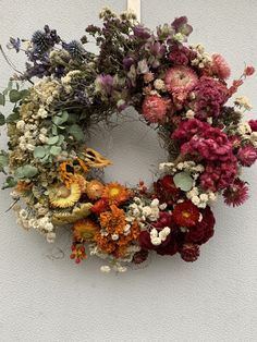 a wreath with dried flowers hanging on the wall