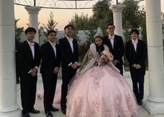 a group of people standing next to each other in front of a white gazebo