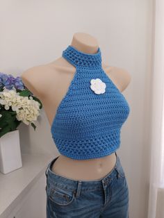 READY TO SHIP NOW  Sky blue mock neck crochet crop top with flower detail is perfect to wear to beach, parties, clubs or festivals. FIND MORE TOPS HERE: https://www.etsy.com/your/shops/me/tools/listings/section:29518142,sort:title,order:ascending,stats:true Size: small to med          MODEL'S MEASUREMENTS:  Bust: 87cm under bust:  72cm Made from 100% acrylic  All items listed in my store are a finished product and are ready to be shipped immediately.   MADE IN A SMOKE FREE ENVIRONMENT 😊 Summer High Neck Crop Top, High Neck Crop Top For Summer, Handmade Blue Tops For Festival, Spring Summer Halter Top With Crochet Trim, Spring Halter Top With Crochet Trim, Bohemian Cropped Halter Top For Spring, Trendy Spring Party Crochet Top, Spring Festival Halter Top With Crochet Trim, Fitted Halter Top With Crochet Trim For Spring