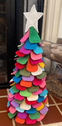 a colorful christmas tree made out of paper and felt with a white star on top