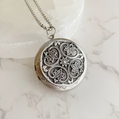 "Now offering custom text engraving.  Visit shop for details. Elevate your style with this stunning and timeless antiqued silver locket. The perfect blend of vintage charm and modern elegance, this piece will complement any outfit, whether dressed up or casual. Crafted from high-quality plated brass, this locket is both lightweight and durable. The 32mm diameter makes it a perfect size for any neckline. The locket opens to reveal a secret place to keep your cherished pictures or messages close to your heart. The locket comes with a stainless steel rolo chain, available in 18\", 20\", 24\" or 30\" length. The hypoallergenic nature of stainless steel makes it an excellent choice for those with sensitive skin. Plus, it will never tarnish or lose its shine, ensuring that this beautiful piece w Wedding Locket, Engraved Locket, Picture Locket, Secret Place, Silver Locket, Silver Lockets, Asheville Nc, Rolo Chain, Locket Necklace