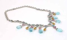 "This is a breathtaking white gold, diamonds and gemstone ladies drop style necklace. The piece is exquisitely crafted in solid 18k white gold with a smooth polished finish adorned with round cut sparkling diamonds accented with pink and blue topaz and citrine gemstones. The links of this amazing necklace are in open heart shape with the front hearts in graduate size adorned with pave sparkling diamond. The briolette cut large topaz gemstones dangle below multi floral fancy drop links. 18k white Luxury Drop Multi-stone Jewelry, Formal Multi-stone Drop Jewelry, Multi-stone Diamond Necklace In Fine Jewelry Style, Elegant Multi-stone Drop Necklaces, Elegant Multi-stone Diamond Necklace Gift, Multi-stone Briolette Diamond Jewelry, Briolette Multi-stone Diamond Jewelry, Topaz And Citrine, White Gold Necklace