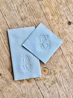 two blue napkins sitting on top of a wooden table