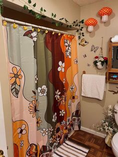 a bathroom with a shower curtain, toilet and rugs on the floor in front of it