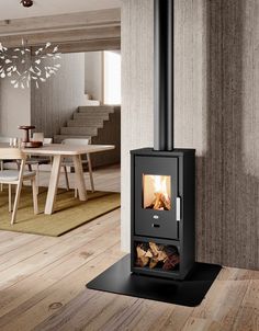 a wood burning stove in a living room next to a dining room table and stairs