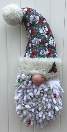 a santa clause hat hanging on the side of a white wooden door with ornaments around it