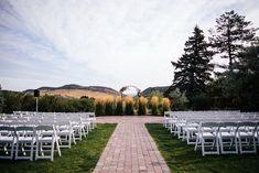 rows of white chairs set up for an outdoor ceremony