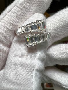 three stone diamond ring sitting on top of a white glove with other items in the background