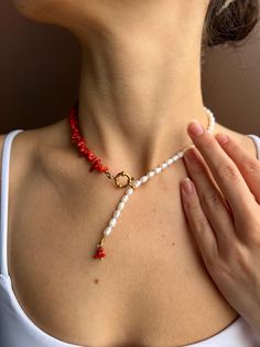 This elegant choker blends the classic beauty of freshwater pearls with the bold allure of red agate stones. The unique asymmetrical design features a striking contrast, with one side showcasing lustrous pearls and the other adorned with vibrant red agate chips, all linked by a gold-toned clasp. The delicate drop of pearls and agate at the center adds a modern twist to this sophisticated piece, making it perfect for those who love to stand out with timeless style. Whether worn alone or layered, Elegant Red Beaded Necklaces With Natural Stones, Elegant Red Beaded Necklace With Natural Stones, Elegant Red Pearl Necklace, Elegant Red Pearl Necklace With Gemstone Beads, Elegant Red Necklace With Pearl Charm, Elegant Red Pearl Necklace Gift, Adjustable Red Jewelry With Pearl Charm, Elegant Red Pearl Necklace With Natural Stones, Adjustable Red Pearl Necklace