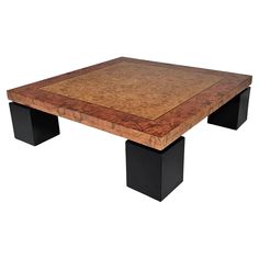 a square coffee table with black legs and a burlwood top on an isolated white background