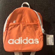 Adidas Peach Colored Mini Book Bag. Nwt. Casual Orange Backpack Bag, Casual Softback Backpack For Errands, Sporty Back To School Bags, Orange Backpack With Zipper Closure, Casual Orange Backpack, Casual Orange Standard Backpack, Adidas Pink Backpack For Daily Use, Pink Adidas Travel Backpack, Pink Adidas Backpack For Daily Use