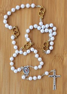 "Personalized rosary with white pearls beads for wedding. Wedding rosary with a name for newlyweds. If you want to brighten up someone's wedding day and give them a personal gift, you can order a wedding rosary with a name. This beautiful rosary it's perfect gift for wedding. In every part of Our Father is two rings what symbolizes weddings. Its made with medal Virgin Mary and cross MIR, MIR, MIR ( PEACE, PEACE, PEACE). You can order: 1.only rosary 2.rosary with one name(only bride or only groom Wedding Rosary Bracelet With Pearl Charm, Wedding Pearl Rosary Bracelet With Round Beads, White 8mm Beads Jewelry For Anniversary, White Pearl Charm Jewelry For First Communion, White Pearl Rosary As A Gift, White Pearl Rosary As Gift, Elegant White Rosary For First Communion, Spiritual Wedding Jewelry With 8mm Beads, Spiritual 8mm Beads Jewelry For Wedding