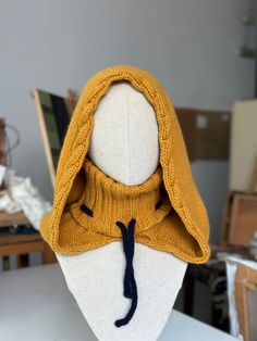 a mannequin wearing a yellow sweater with a hood on it's head