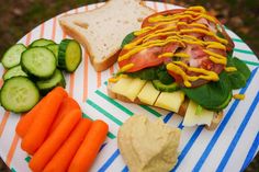 a sandwich with cheese, lettuce and carrots on a plate