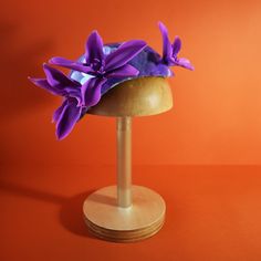 "Hand-crafted Hat in Purple color from the \"THALASSOPHILE\" Hat and Headpiece Collection by Stavroula P. Spyrou. *A NEW Collection inspired by the sea and Greece.  The word \"Thalassophile\" derives from the combination of the Greek words Thalassa (Θάλασσα: in English 'sea') and  Phile (Φίλος (friend): in English lover, beloved).  A unique hat with sequins embroidered by hand where you can wear it in any occasion, if you love appearances at the Royal Ascot, New Year's Eve or a birthday party. o Materials and Colors: -Iridescent transparent sequins in purple color -Cold Porcelain Exotic Flowers in purple color -Silk Shantung Lining and bias fabric in light salmon and light blue color -Double Elastic in ecru color and a silver comb (at the bottom) to keep the hat in place. -Size: Length: 25 Ceremonial Blue Adjustable Hat, Adjustable Blue Ceremonial Hats, Adjustable Cloche Hats For Ceremonies, Adjustable Cloche Hat For Ceremony, Adjustable Ceremonial Headpiece With Pinched Crown, Handmade Purple Party Hat, Adjustable Structured Crown Headpiece As Gift, Handmade Fascinator As Gift, Adjustable Handmade Flowers Headpiece For Kentucky Derby