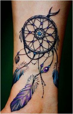 a woman's foot with a tattoo on it that has a dream catcher and beads