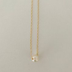 Just A Pearl! This simple yet elegant necklace is part of my Just A Pearl collection. One single pearl dangles from a delicate gold necklace. It measures 16 inches and length and can be adjusted to 15 inches for choker length. Classic Gold Charm Necklace With Pearl Drop, Minimalist Gold Charm Necklace With Pearl, Minimalist Pearl Charm Necklace With Round Pendant, Minimalist Pearl Chain Necklace With Pearl Charm, Minimalist Pearl Drop Necklace With Pearl Chain, Classic Gold Pearl Chain Charm Necklaces, Classic Gold Charm Necklace With Pearl Chain, Gold Minimalist Charm Necklace With Pearl Chain, Gold Minimalist Charm Necklaces With Pearl Chain