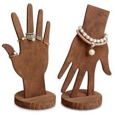 two wooden hand sculptures with pearls on them