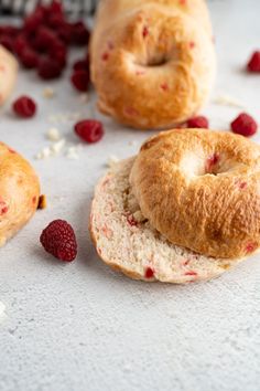 three bagels with raspberries on them and some other pastries